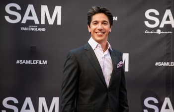 Yan England pose avec sa conjointe connue sur un tapis rouge